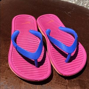 Pink blue and orange Nike flip flops